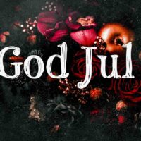Et julebilde med teksten "God Jul" skrevet i hvit, dekorativ skrift. Bakgrunnen er mørk og inneholder røde roser, kongler, glitter og gyldne epler, som skaper en varm og festlig julestemning.