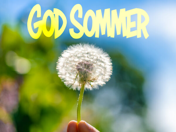 "En hånd holder en løvetann mot en blå himmel, med teksten 'God Sommer' i gule bokstaver."