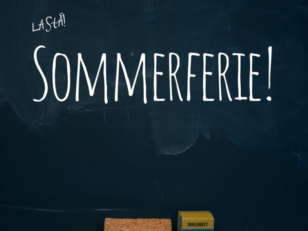 Sommerferie skrevet på en skoletavle, nedenfor ligger en svamp og en pakke med skolekritt.