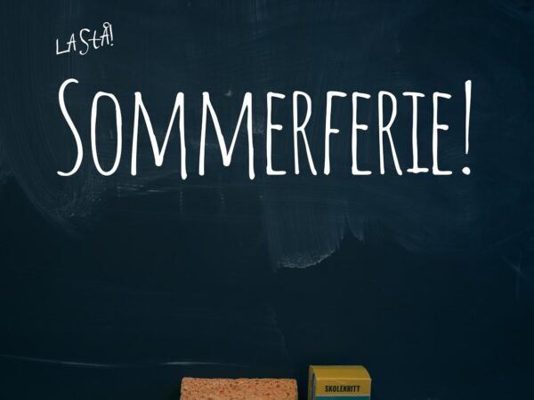 Sommerferie skrevet på en skoletavle, nedenfor ligger en svamp og en pakke med skolekritt.