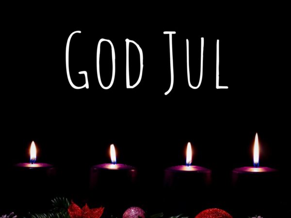 Bilde av 4 adventslys og skriften GOD JUL, med kongler og rød julepynt
