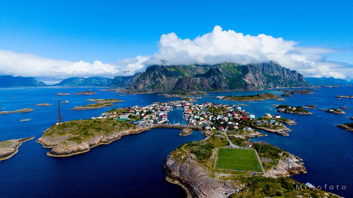 Henningsvær fotballbane - Lofoten Henningsvær fotballbane, også kjent som Henningsvær Stadion, er en unik idrettsplass som ligger i fiskeværet Henningsvær i Lofoten, Norge. Banen er kjent for sin spektakulære beliggenhet midt i det dramatiske nordnorske landskapet, omgitt av fjell og hav. Den ligger på en liten holme, noe som gir en imponerende utsikt og en helt spesiell atmosfære for både spillere og tilskuere.