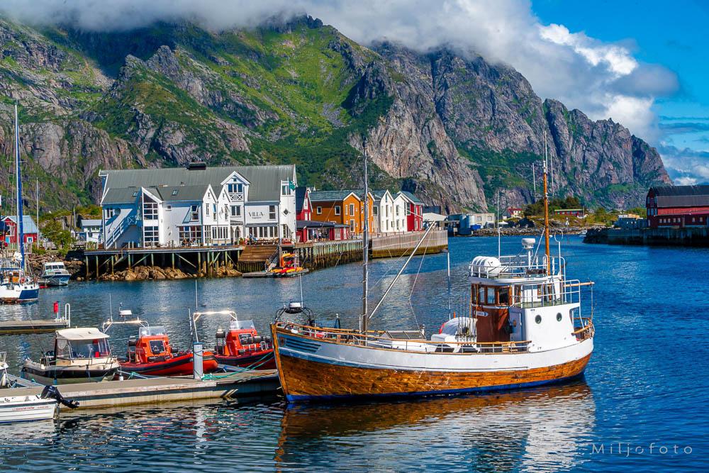 Foto av en Fiskebåt i Lofoten, som ligger til kai med fjell i bakgrunn